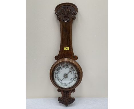 A late Victorian oak aneroid wall barometer. 35' high. Formerly with a temperature scale