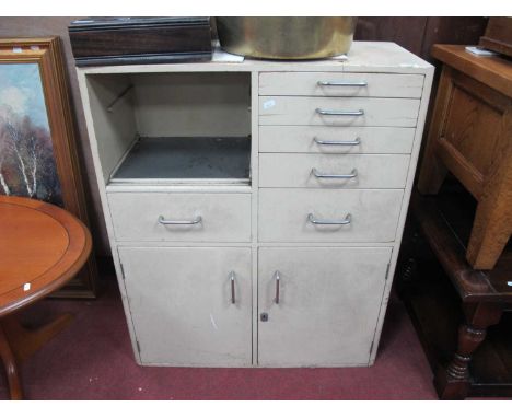 A Vintage Cream Painted Wood Dentists Cabinet, with a configuration of six drawers and open shelf over two cupboard doors wit