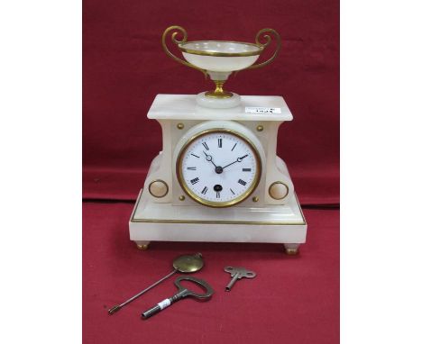 An early XX Century French marble mantle clock with a gilt mounted urn finial over a white enamel dial, Roman numerals, plint