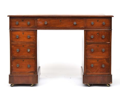 A Victorian mahogany pedestal desk, of neat proportions, the gilt tooled skiver over a traditional arrangement of nine drawer