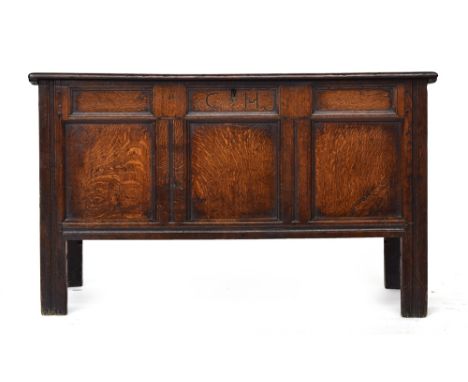 An 18th century and later three panel oak coffer, carved with initials 'CH', with fitted candle box, 121x53x72cm highProvenan
