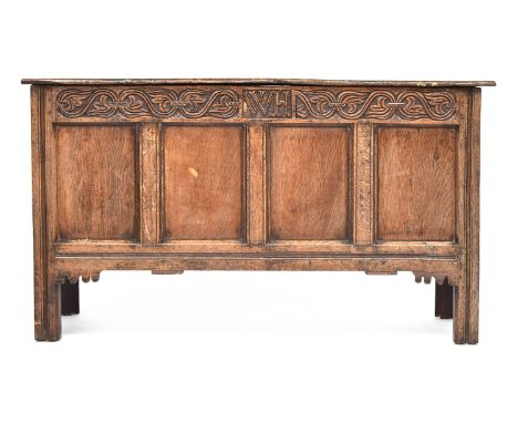 An early 18th century four panel oak coffer, carved with initials WH, 134cm wide, 52cm deep, 76cm high 