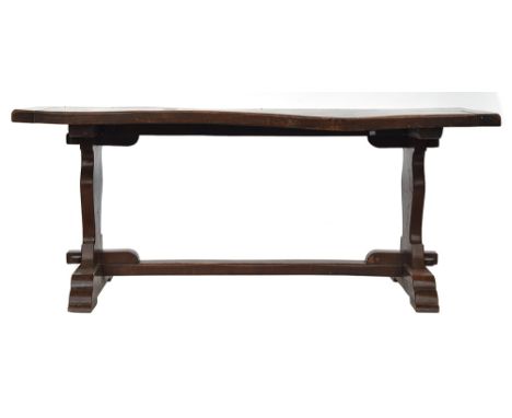 An oak refectory table, two plank cleated top, each support with carved shield motif, 181cm wide, 83cm deep, 77cm high 