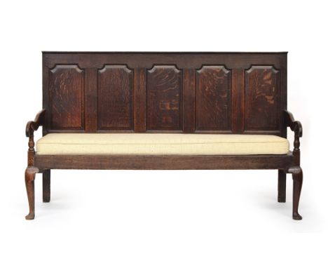 A George III oak five panel settle, circa 1770, the panel back above a pair of open ends and solid bench seat, with removable