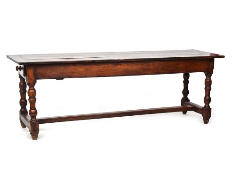 A fruitwood and oak refectory style table, three plank top with cleated ends, single end drawer, on baluster turned supports,