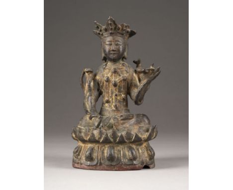 A BRONZE SEATED FIGURE OF A BODHISATTVA China, Yuan/Ming dynasty Bronze. H. ca. 23 cm. The bodhisattva is seated on a lotus b