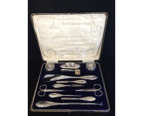 An early 20th century engine turned silver gentleman's manicure set with vacant cartouches: Chester 1922 in original velvet a