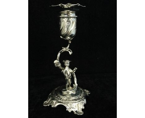 An ornate silver candlestick with figural stem: London 1902.