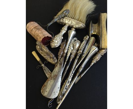 A quantity of various silver button hooks and shoe horns together with various other silver items.