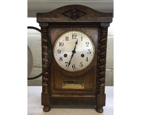 An early 20th century oak cased mantle clock with presentation plaque.