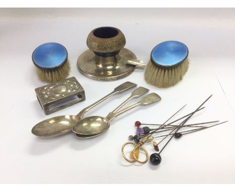 A silver candlestick, three silver spoons, enamel and silver backed brushes, stick pins etc. Shipping category B.