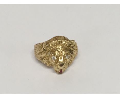 A 14carat gold ring in the form of a lions head the eyes brilliant cut diamonds and ruby mouth ring size V weight 13g