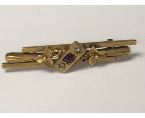 A Edwardian 15 ct gold brooch inset with small central ruby flanked by diamond chips total weight 4 grams.