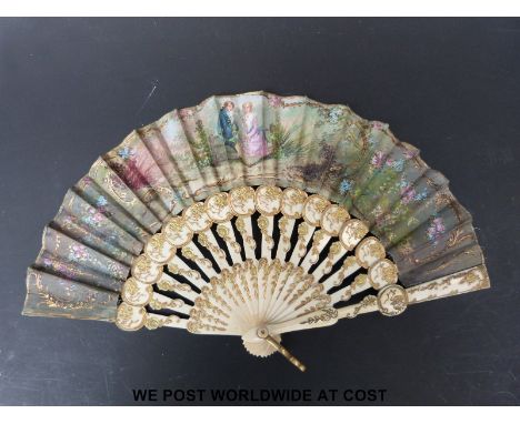A late 19thC fan with bone and gilt decorated sticks and painted scene in a box of a couple sitting on a fence. Signed  F E R