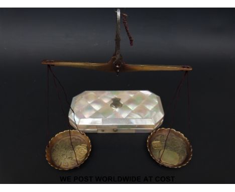 A mother of pearl cased set of travelling beam scales with engraved pans and various troy oz and other weights 