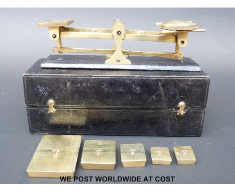 A set of travelling leather cased set of postage scales having rectangular flat weights 