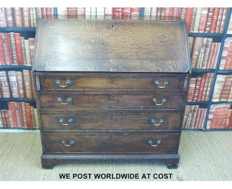A Georgian oak bureau, the interior with drawers and various secret compartments, the base with four graduated drawers and br