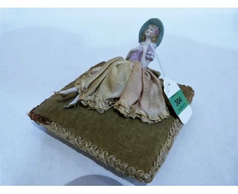 An early 20th century pin cushion doll, the cushion 6¼'' wide