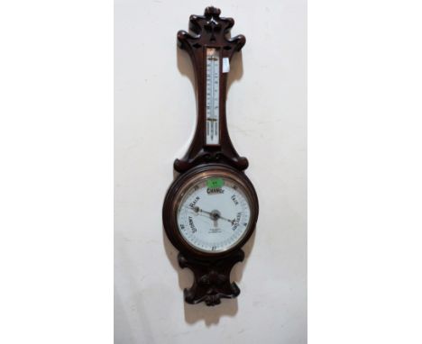 A late Victorian oak cased aneroid barometer, the enamel dial signed Benn Franks, Optician. 32'' high. Crack to dial