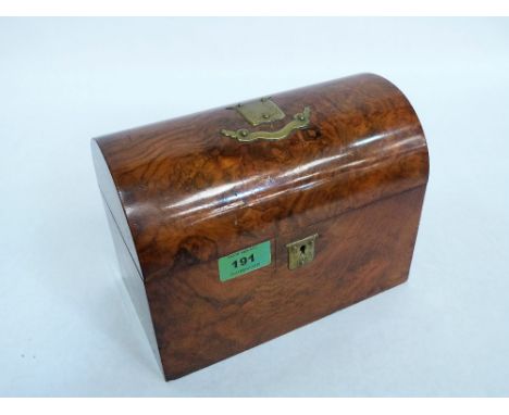 A Victorian burr walnut tea caddy, the domed lid with brass cartouche and scroll. 9'' wide