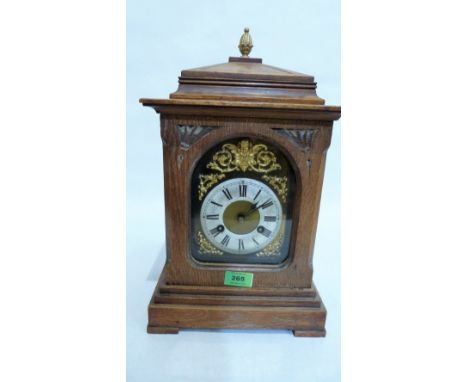 A German oak mantle clock, the Junghans movement striking on a coiled gong, the brass dial with silvered chapter. 16'' high