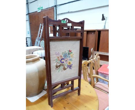 A mahogany and embroidered diptych firescreen