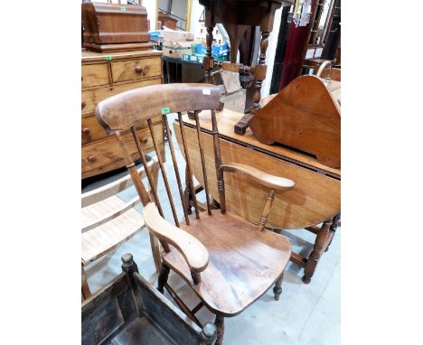 A Victorian kitchen elbow chair with stick back and elm seat on ring turned splayed legs