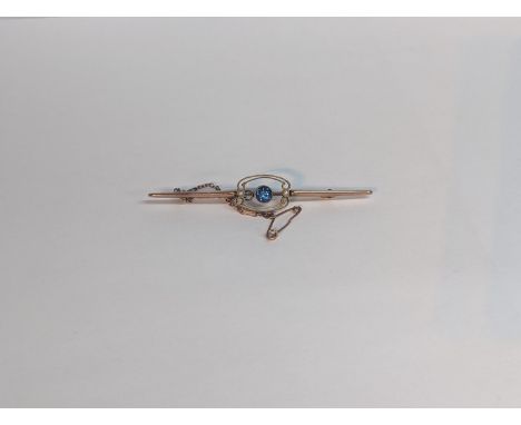 A yellow metal Edwardian bar brooch inset with central blue stone flanked by seed pearls, with safety chain, 2.6gLocation: CA