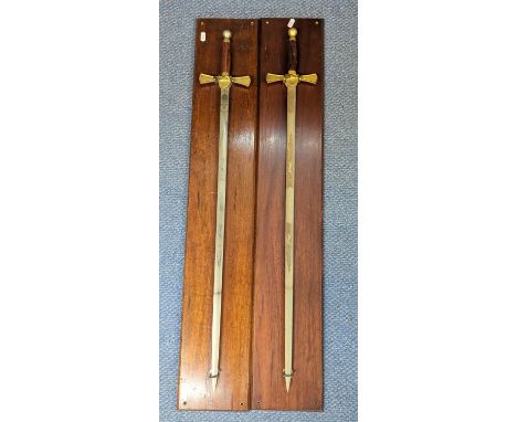 A pair of Wilkinson Sword commemorative swords, blades etched with greyhounds and to brass cross guard, on presentation wall 
