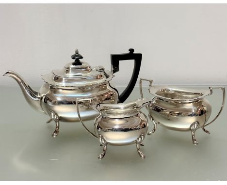 An Epns three piece tea service comprising teapot with scalloped border, matching sugar basin and cream ewer raised on pad fe