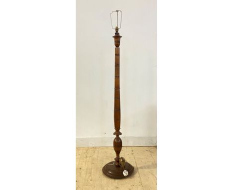 A turned walnut lamp standard, first half of the 20th century, with floral carved bands, on a circular base, H153cm
