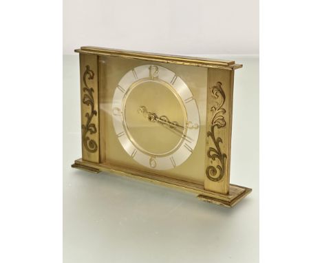 A mid century brass rectangular mantel clock with simple silvered bordered dial with Arabic numerals at quarters and baton ma