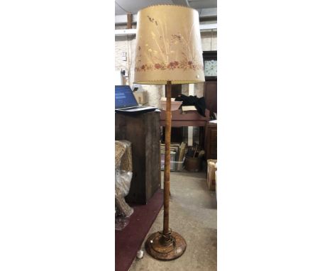 A vintage burr walnut standard lamp with decorative pressed flower and grass parchment shade