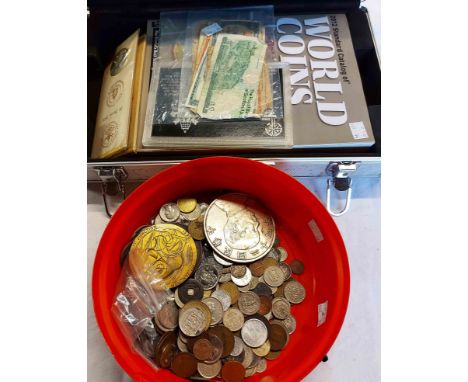 A tub containing a quantity of world coinage - sold with a case containing foreign notes and coin catalogue