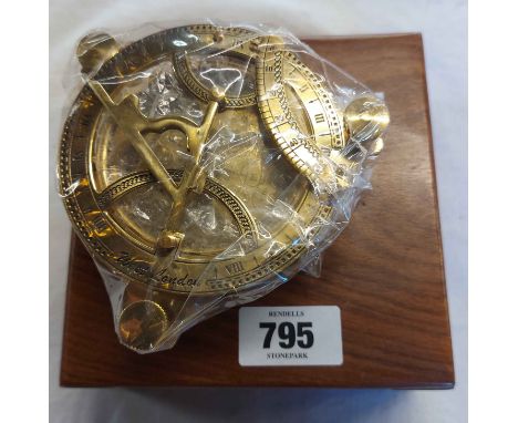 A modern reproduction brass sundial set in wooden case