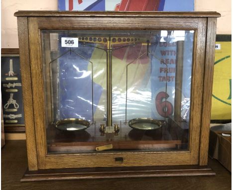 A set of vintage laboratory scales and weights set in a wooden slide front case