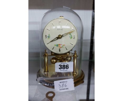 A small vintage Kundo anniversary clock with ball pendulum under glass dome