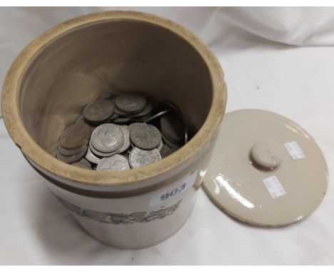 An antique ceramic kitchen storage jar containing a large quantity of post 1947 half crowns, etc.