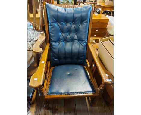 An early 20th Century oak framed drawing room open armchair with studded and button back blue leatherette upholstery, set on 