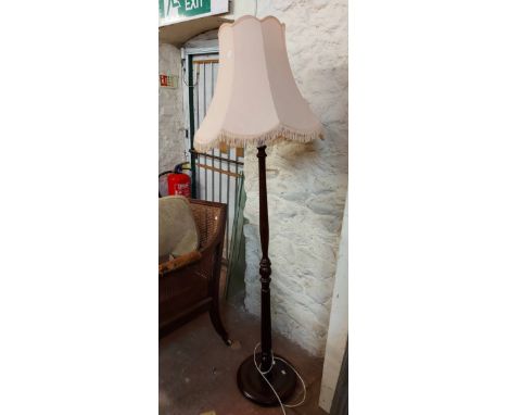 A vintage stained wood standard lamp, set on turned and fluted pillar and circular base - with light pink shade