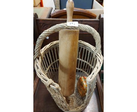 A wicker plate basket containing a large rolling pin and a lacquered box