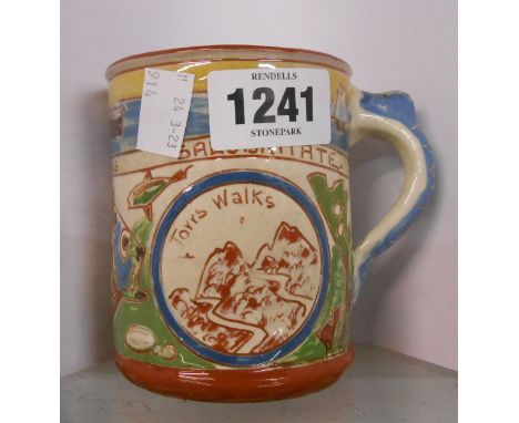 A Baron Barnstaple pottery Ilfracombe souvenir mug with sgraffito design depicting a seascape and grotesque fish with coloure