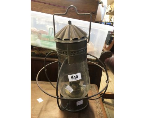 A brass hanging oil lamp of cage form with glass shade