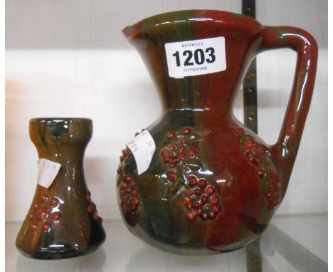 An Elton Sunflower pottery Clevedon jug with enamelled floral sprays on a streaky red and green lustre ground and black paint