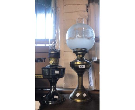 An Aladdin oil lamp with plated finish and glass chimney - sold with a brass similar with etched and frosted globe shade and 