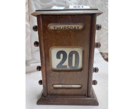 A vintage oak cased desk calendar of roller form