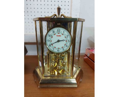 A Kundo faceted cased anniversary clock with ball pendulum and battery movement