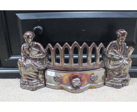 20TH CENTURY LUSTRE FINISH CAST IRON FIRE GRATE
marked 'The Apostle Set', with two robed figures supporting a angled grid wit