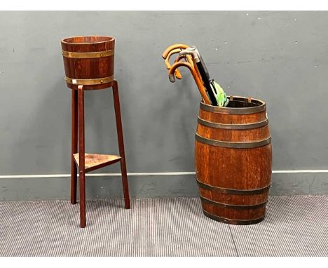 An early 20th century coopered oak barrel as a stick stand, another coopered planter on stand, together with sticks and a ebo