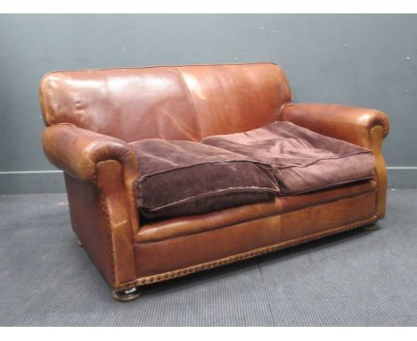 A modern brown leather two seater sofa and armchair in bun feet in Edwardian style. Sofa 78cm x 156cm x 82cm, armchair 82cm x